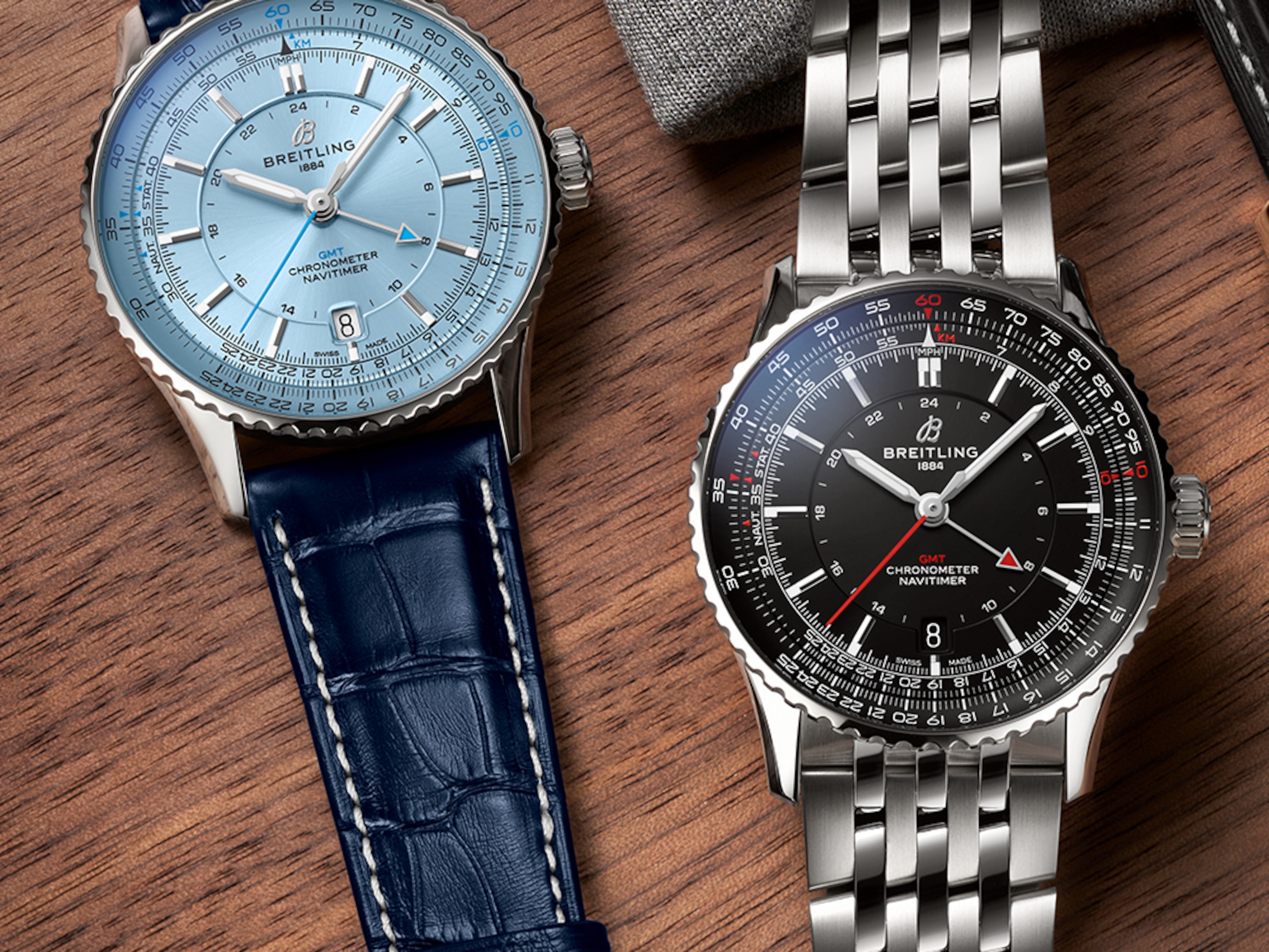 Navitimer with a light blue dial and Navitimer with a black dial on a table.