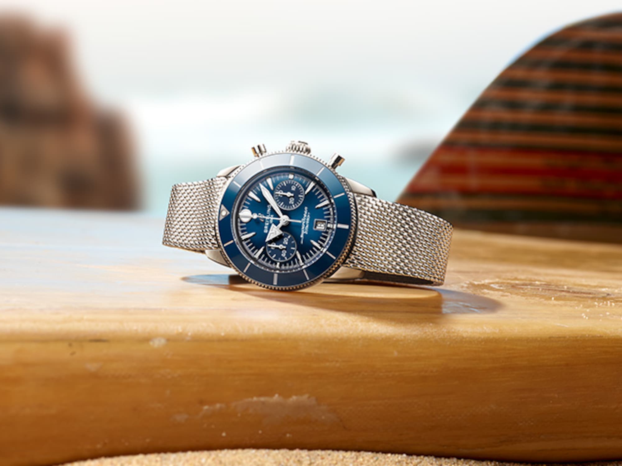 A dark blue Superocean Heritage lies on a table with a magazine and a white rope.