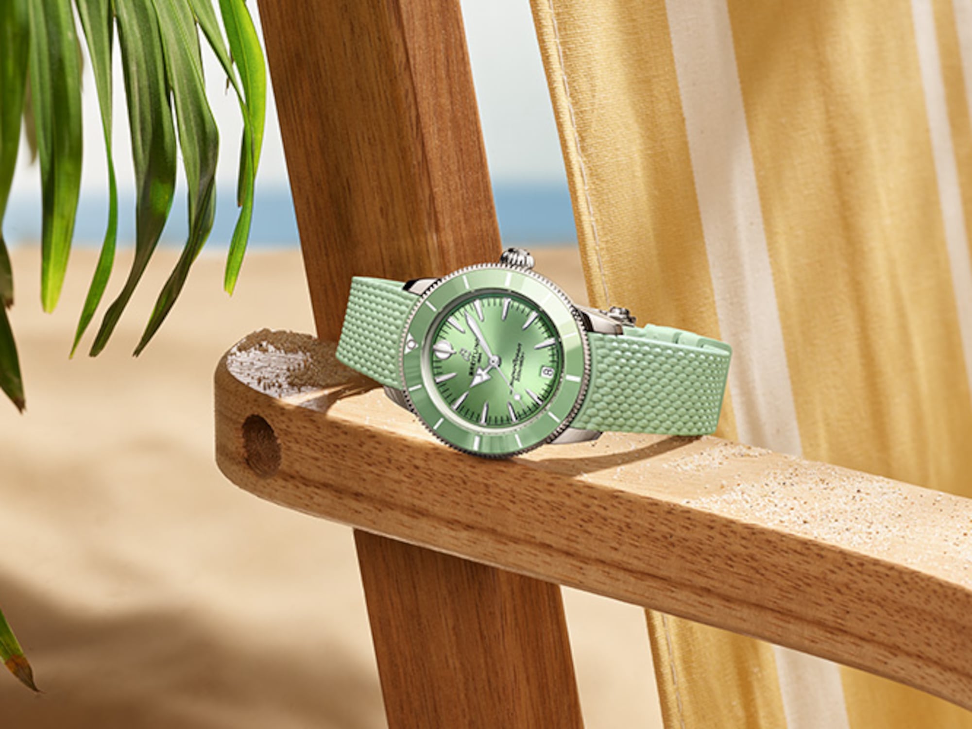 Four different colored Superocean Heritage watches lie on a brown cloth.